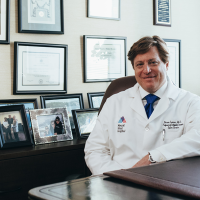 A doctor sitting at a desk in a white coat
