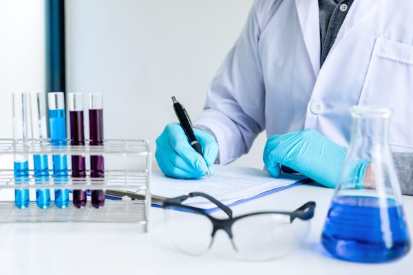 Biochemistry laboratory research, Chemist is analyzing sample an Biochemistry laboratory research, Chemist is analyzing sample and record in laboratory with equipment and science experiments glassware containing chemical liquid.